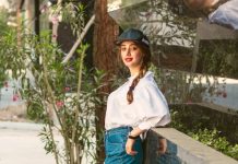 The Art of Effortless Layers: Easy Ideas for a Modern Street Look a woman leaning against a wall with her legs crossed
