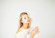 Sparkle, Satin, and Statement Looks for Parties Young blonde woman with glitter makeup and expressive hands.