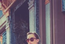 The Everyday Cool Formula: How to Build an Outfit That Looks Easy but Intentional woman in red long sleeve shirt wearing sunglasses standing near brown wooden door during daytime