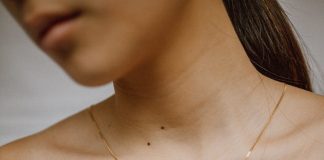 The Finishing Touch: Must-Have Accessories for a Polished Wardrobe woman in white button up shirt wearing gold necklace